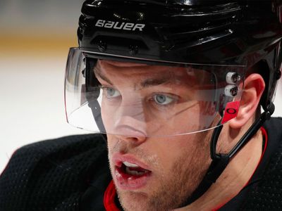Hockey player on ice wearing a clear visor during a game